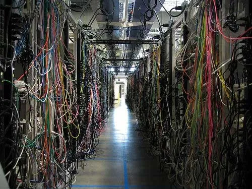 Dichte netwerkbekabeling in een technische corridor
